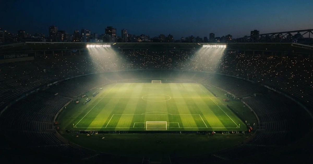 Ein leeres Stadion unter Flutlicht aus großer Entfernung gesehen, Dunst liegt über dem Rasen, die Tribünen sind nur als Lichtpunkte erkennbar.